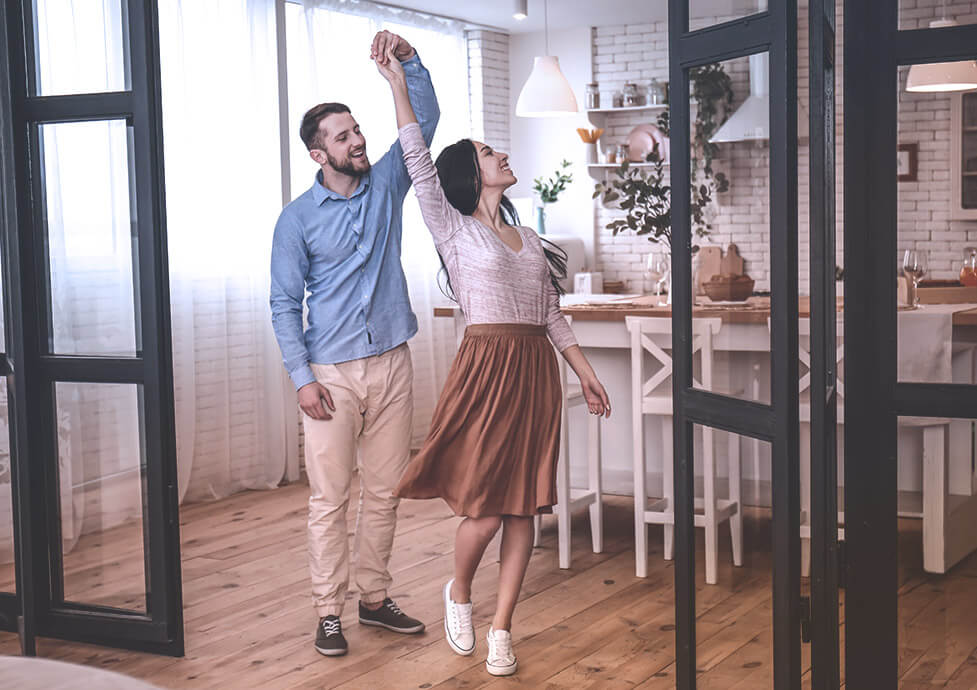A man and a woman dancing in the kitchen